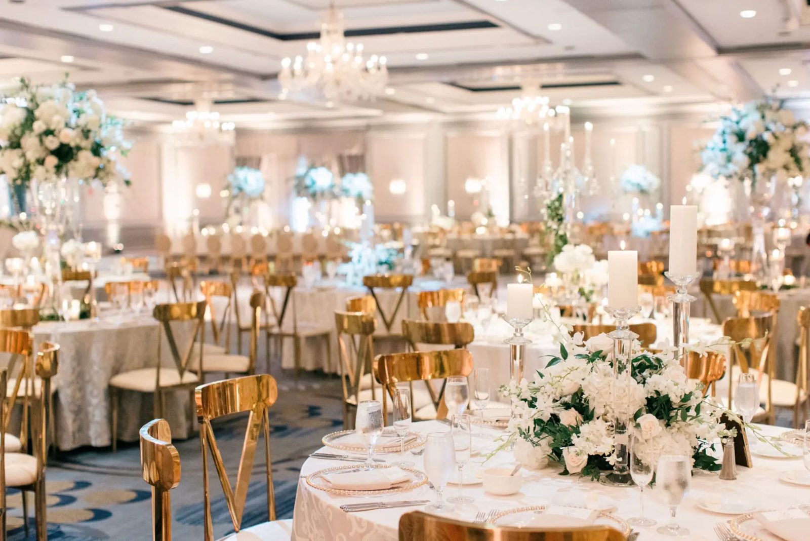 Let's Bloom Florist full ballroom design in white and gold with chandeliers and round tables