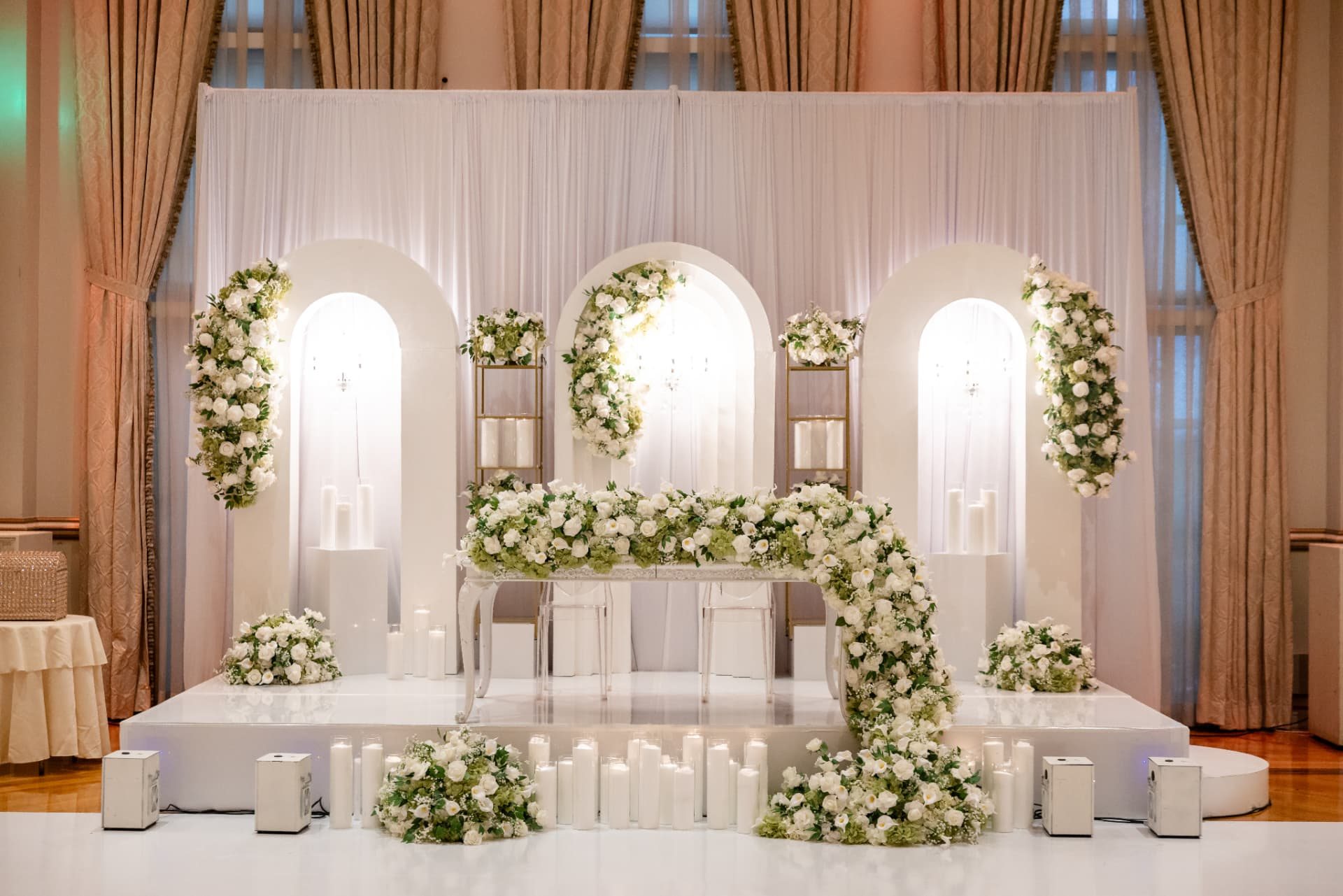 Sweetheart Stage · White Floral Runner Spilling Down the Steps Before Three Backlit Arches — The Tides Estate · North Haledon, NJ, by Let's Bloom Florist