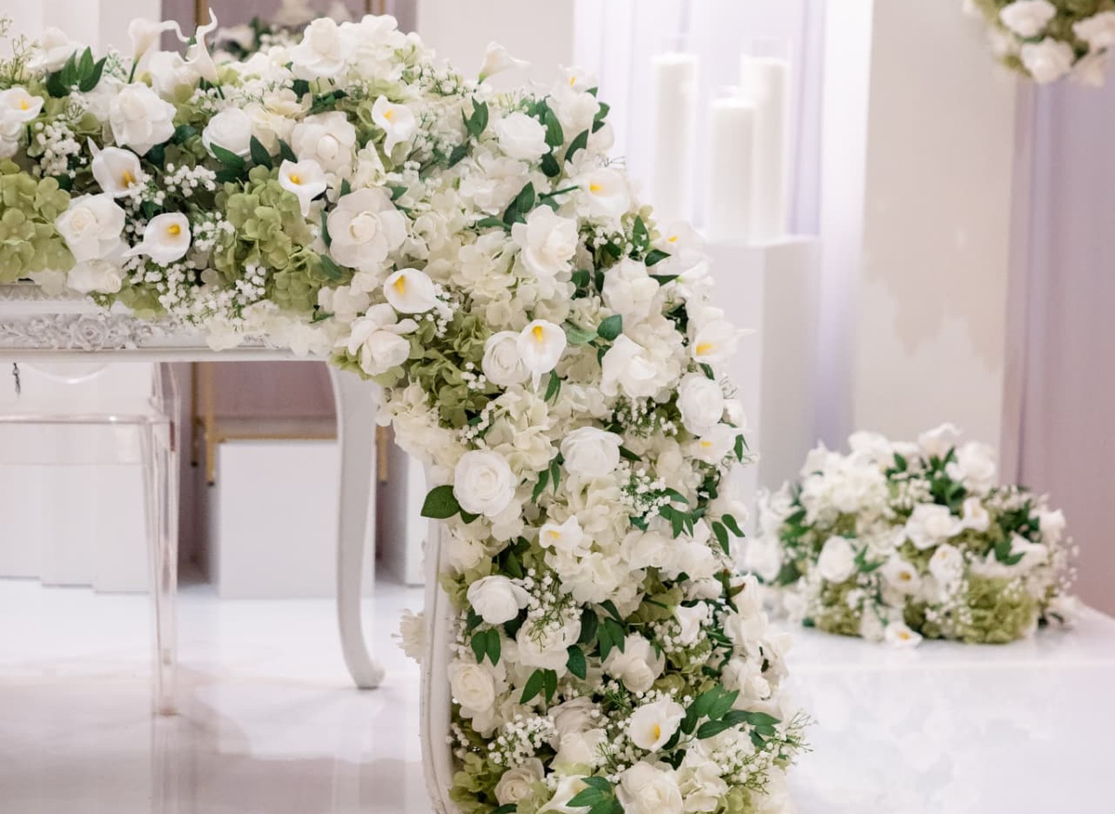 Sweetheart Table · White Rose and Calla Lily Garland Across the Top and Down the Table Leg, with Pillar Candles Behind — The Tides Estate · North Haledon, NJ, by Let's Bloom Florist