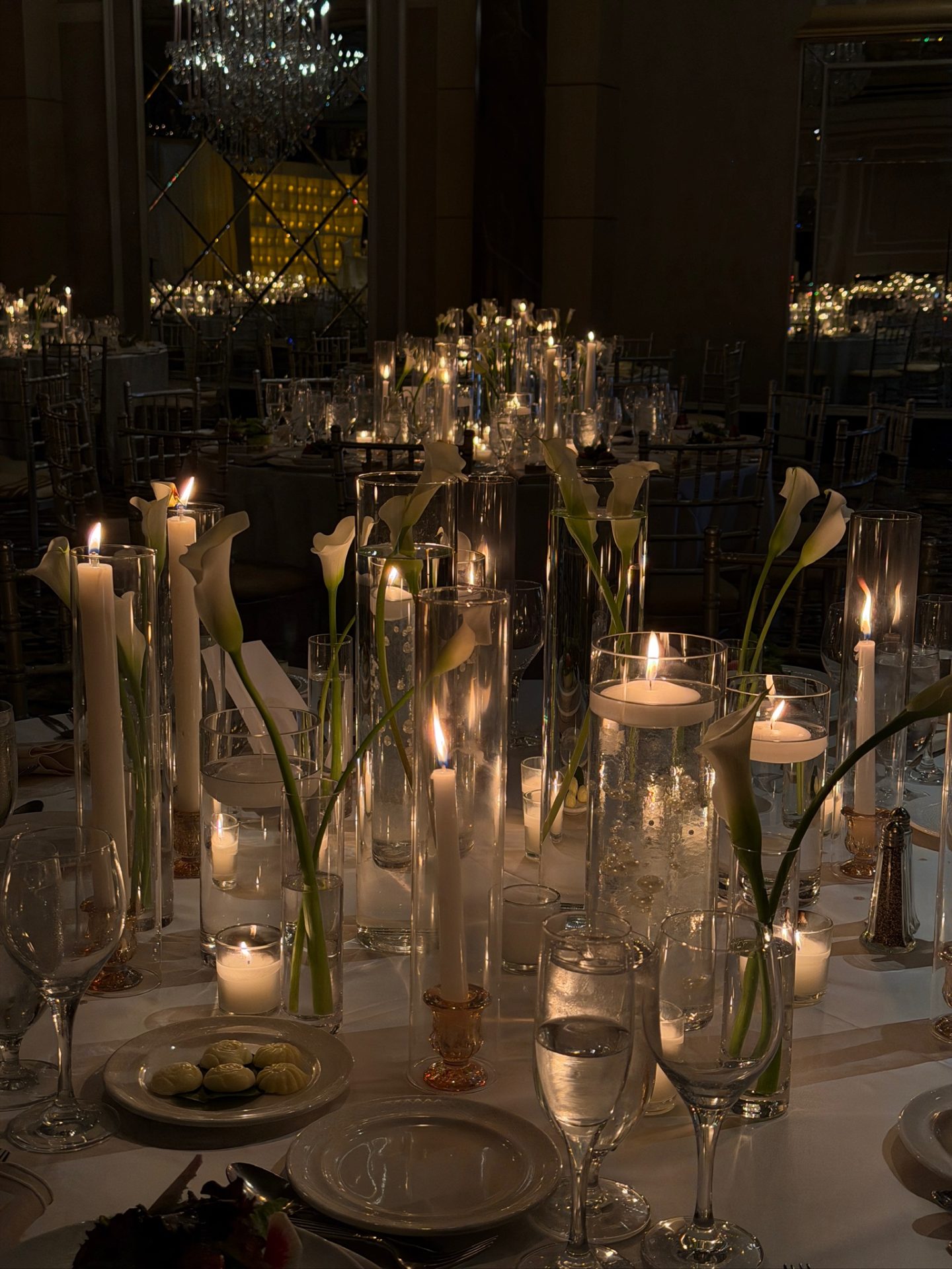 Round table with calla lily glass cylinder and floating candle centerpiece — The Venetian
